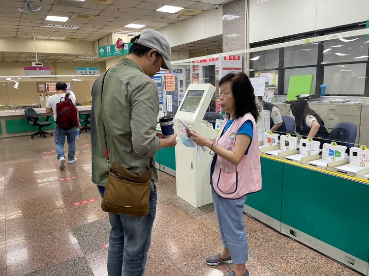 穿上志工背心，王雪梅依舊發揮昔日負責電話諮詢專線的工作精神，為民眾於現場解惑。翻攝畫面