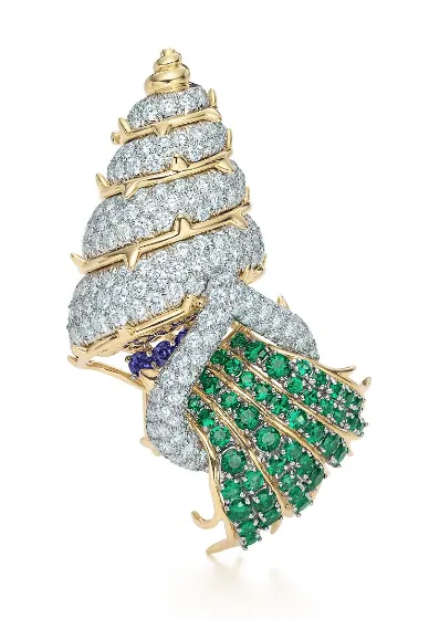 許光漢佩戴的Schlumberger 18K金與鉑金鑲嵌鑽石、祖母綠與藍寶石胸針。品牌提供