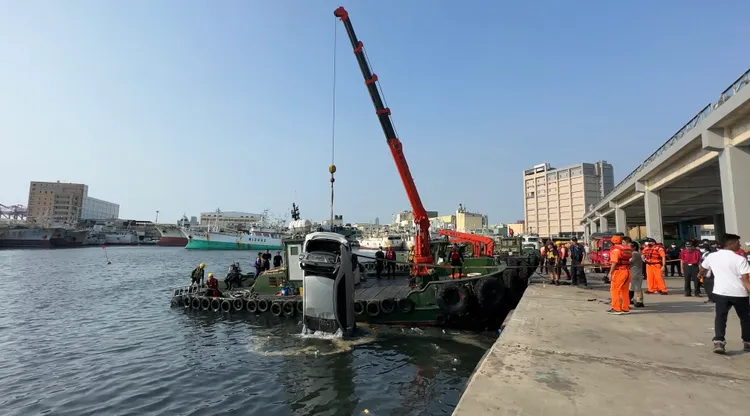 汽車衝過前鎮漁港魚市場落海，警方與消防隊與海巡人員在現場打撈。翻攝畫面