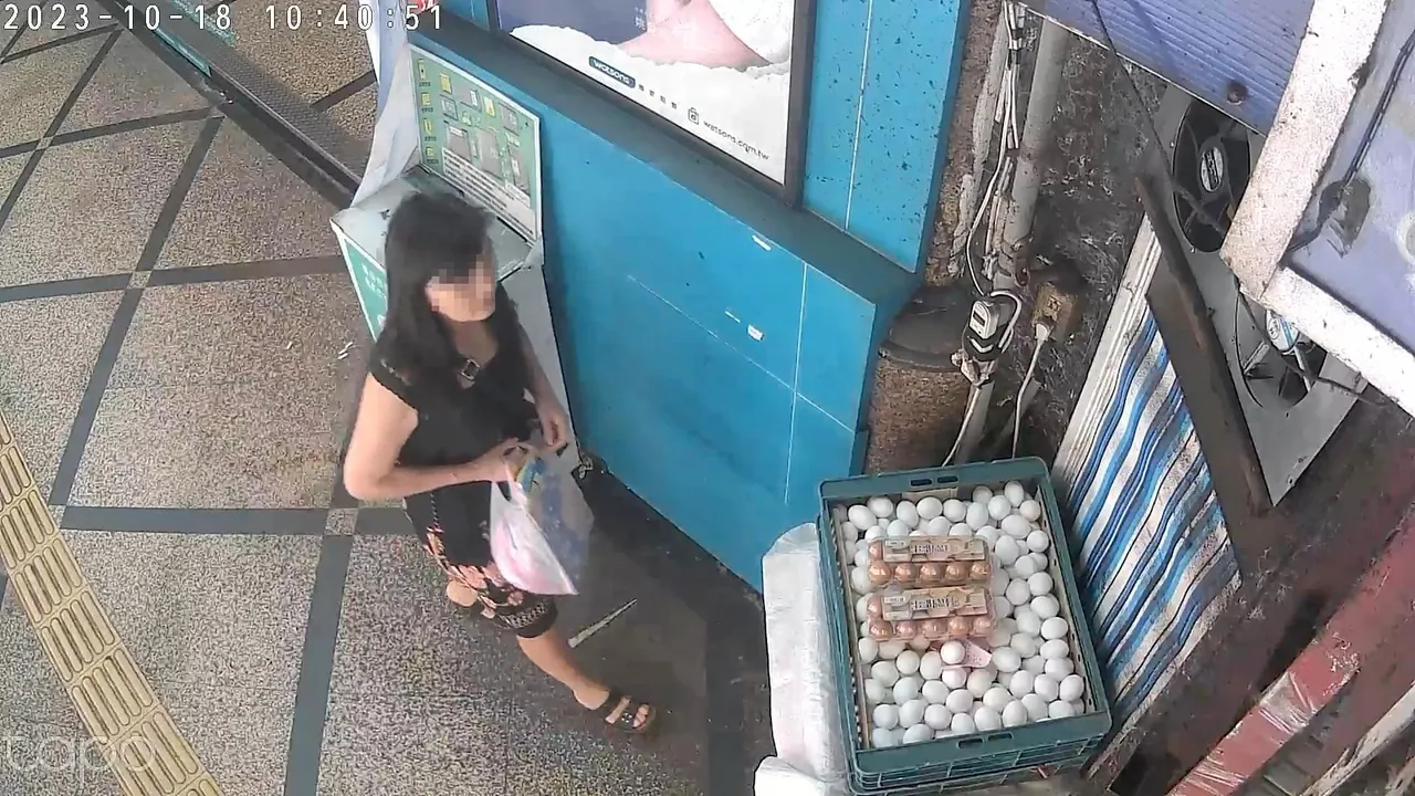 女子靠近该店门口旁摆放的鸡蛋。翻摄自脸书「汐止集团」