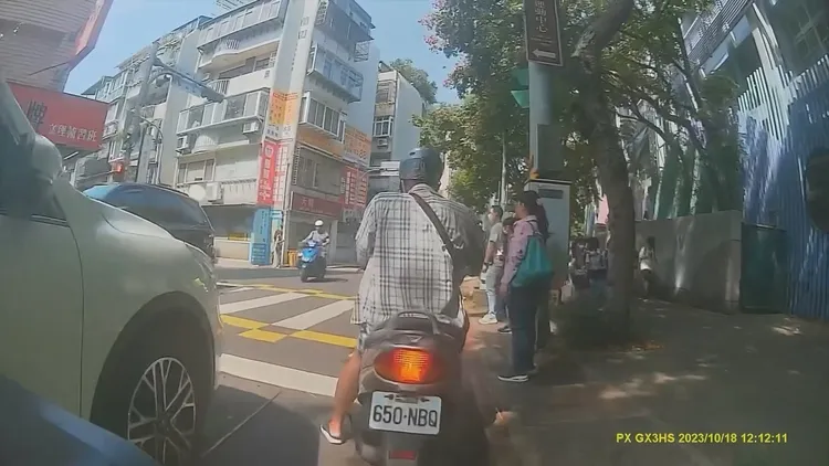 騎士大聲斥責該校導護與師長，引得正步行過馬路的學童頻頻回頭查看。翻攝自臉書「我是士林人~我是北投人~我是大同人」