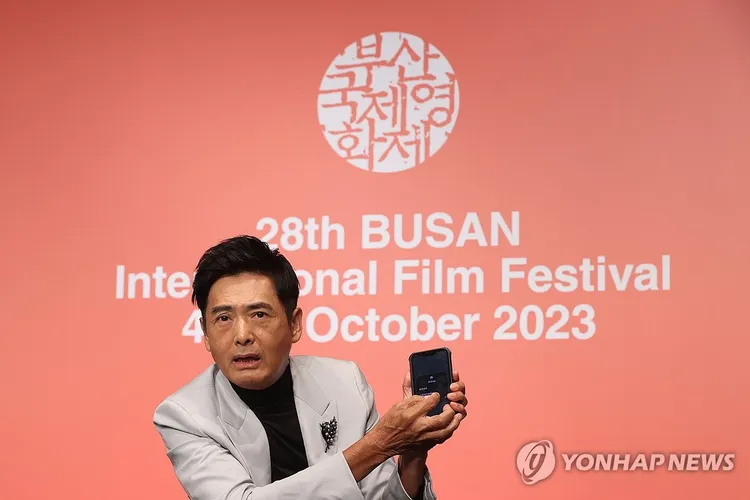 周潤發拍完後，開啟AirDrop功能傳照片給在場的韓國記者。韓聯社