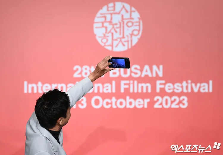 周潤發繼昨晚頒獎典禮跟全場自拍後，今記者會上也拿出手機跟韓國記者合照。xportsnews