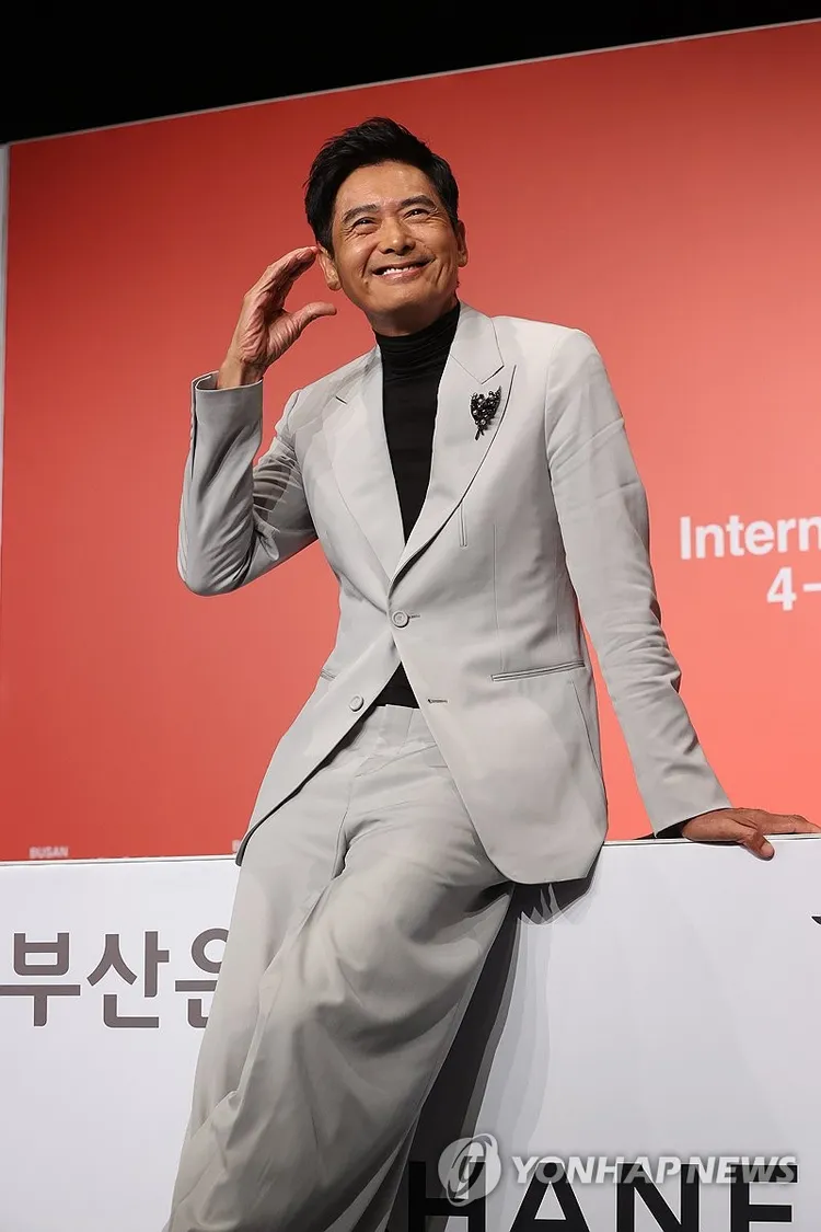 周潤發應媒體要求，比出臉頰愛心。韓聯社