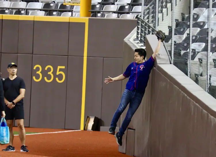 台北市長蔣萬安今天「開箱」大巨蛋，模仿球員跳起來接球並撞上防撞墊。彭欣偉攝