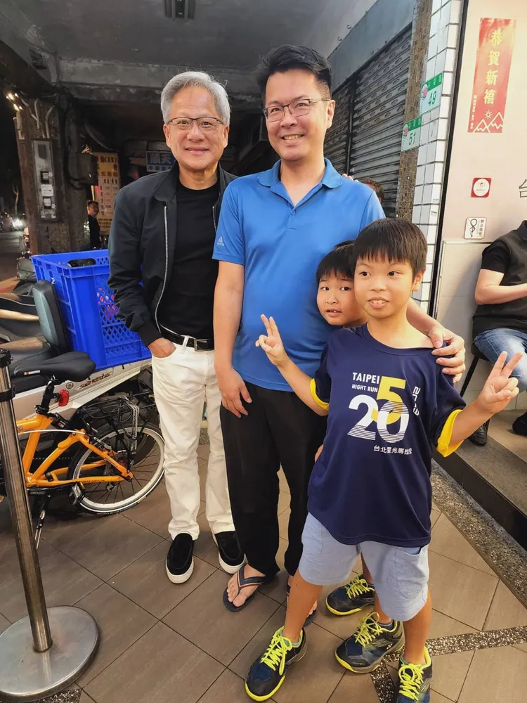 律師陳振瑋巧遇輝達執行長黃仁勳，或黃仁勳主動邀請全家合照，還開心買美食爆漿脆皮魷魚與黃仁勳分享。律師陳振瑋授權提供