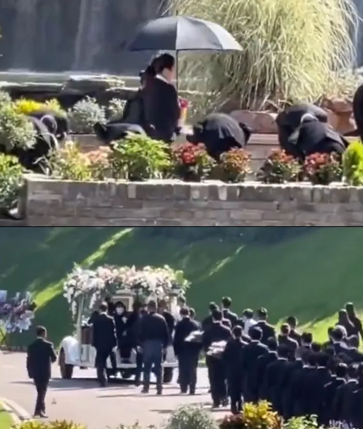 李玟二姊捧著骨灰，由旁人撐黑傘準備進行安葬儀式，大批黑衣人列隊跟隨。翻攝檸檬來了丫微博