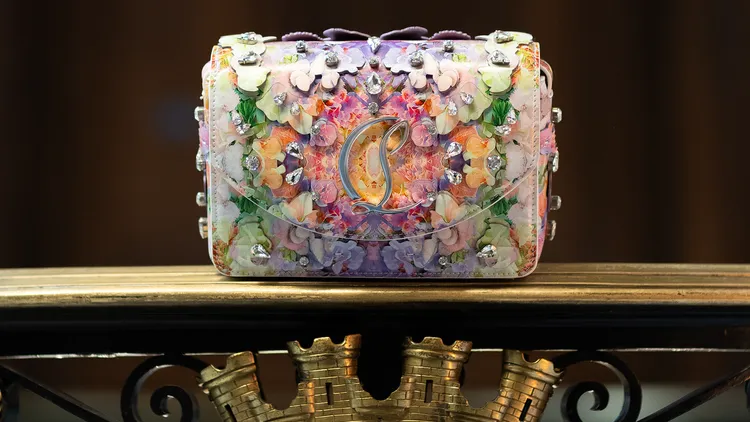 包款滿佈鐳射切割花朵並綴以手工縫製的水晶珠。品牌提供