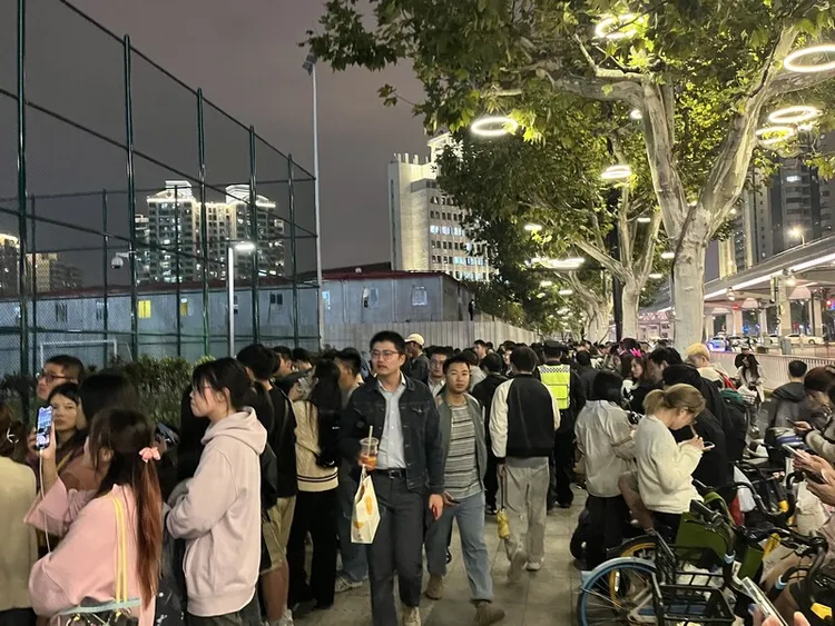 未能搶購到票券入場的歌迷聚集場外，透過表演場地溢出的音樂、燈光沾染一絲演唱會氛圍。圖攝於10月13日。中央社