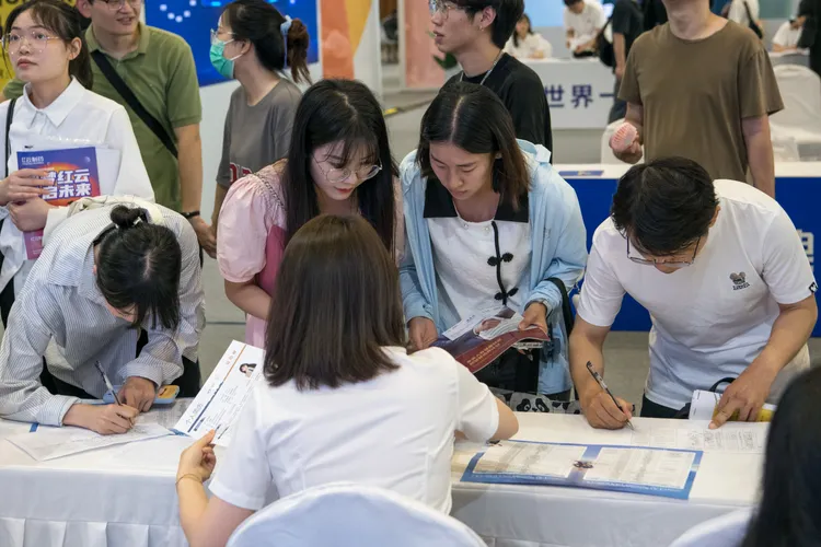 今年7月成都一場職業招聘會上，求職者填寫表格。新華社