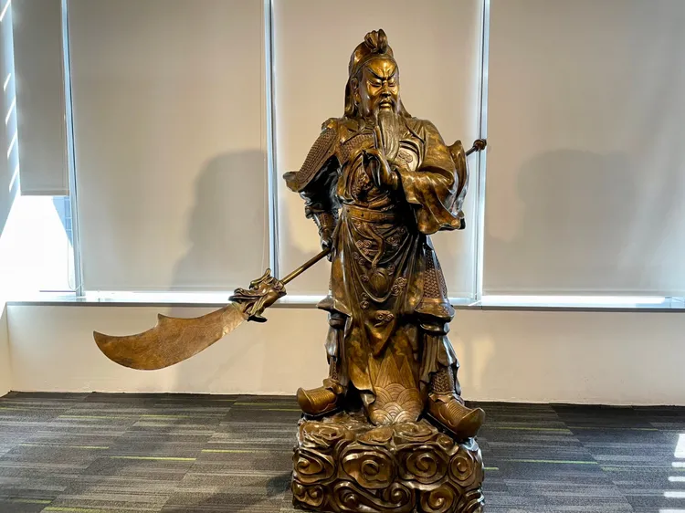 一名電視台攝影撞掉關公，導致關刀掉落，侯辦立刻將關刀歸位。翻攝照片
