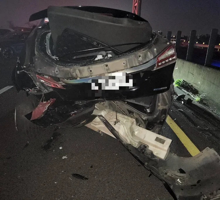轎車車尾陷落，受損相當嚴重。讀者提供