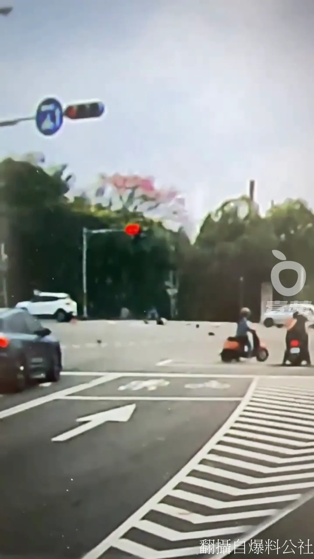 事故發生後，原本在路口停等紅燈的其他機車騎士，嚇得稍微挪開車輛，以避免遭波及。翻攝自爆料公社