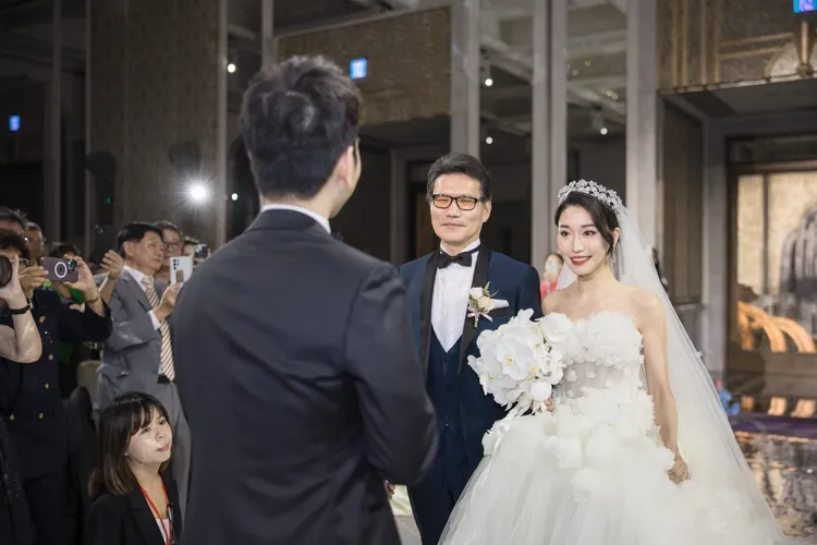 郭父（左）將愛女交到女婿手中。婚顧公司提供