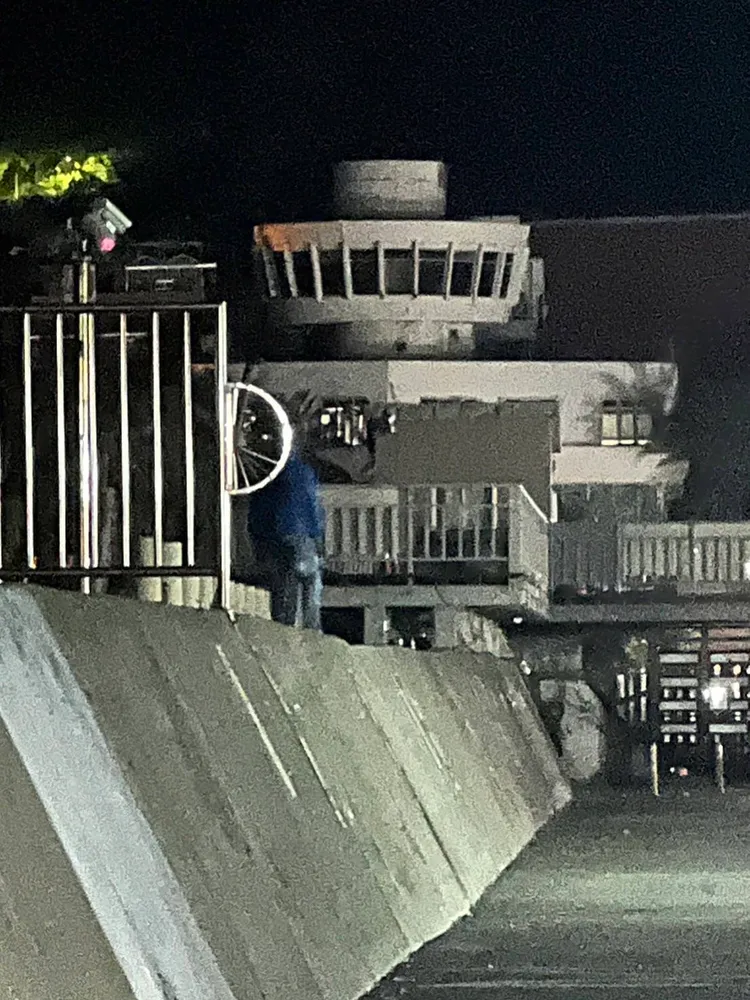 林男在鬼月深夜在西子灣防波堤戴骷顱頭嚇人。翻攝畫面