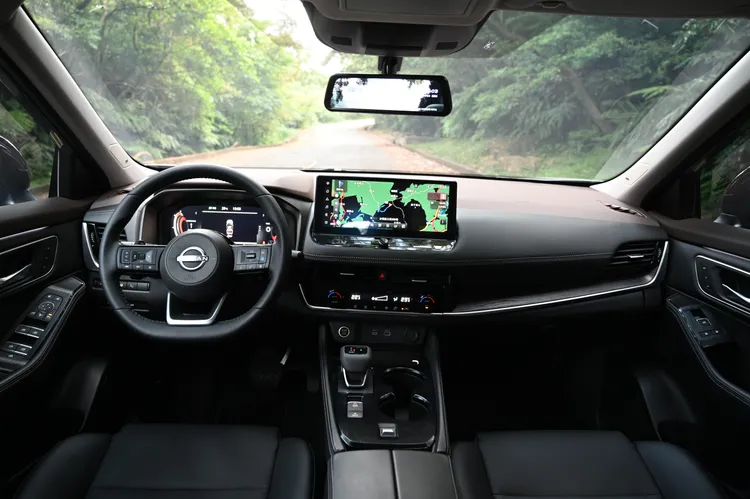 X-Trail輕油電車艙在配色上以黑色為主要基調，並搭配部分深棕色元素，中控台在旗艦車款上覆有軟質皮革，搭配深色木紋飾板、平把式方向盤，整體質感仍有一定水準。林浩昇攝