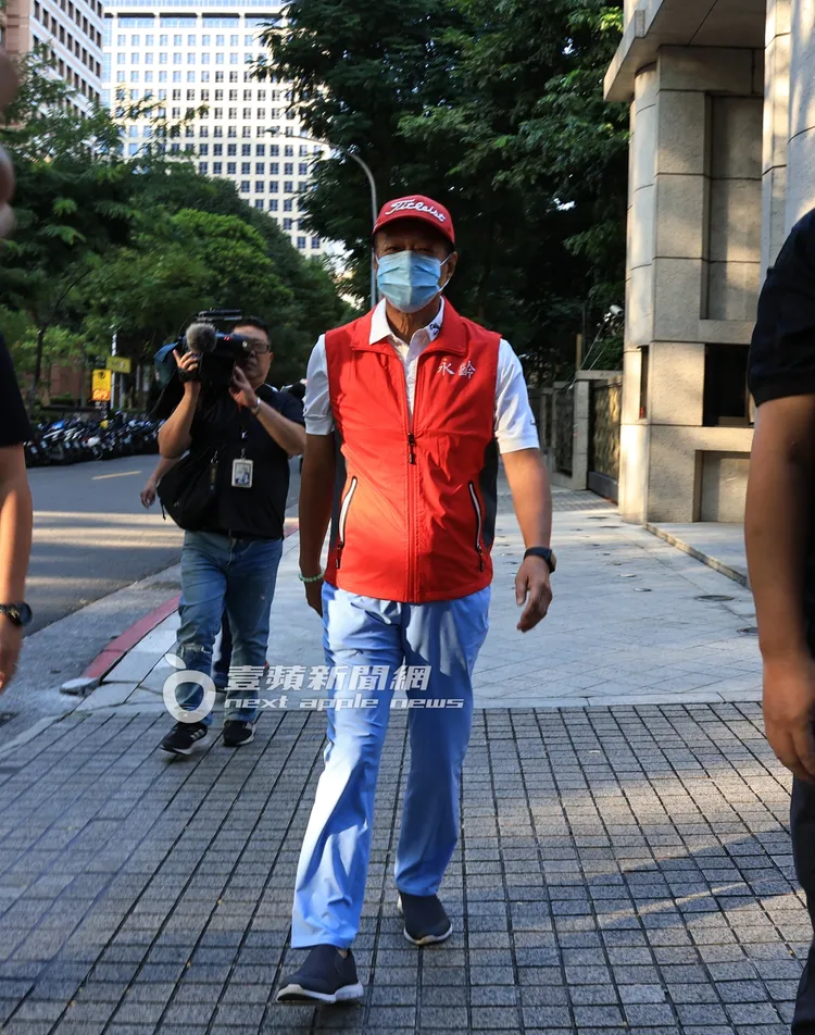 郭台銘身穿紅色永齡基金會背心走在路上。特勤中心攝