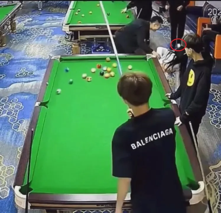 蹲地忍痛的排球妹，慘遭白色母球(紅圈處)高速凌空K頭。翻攝自臉書「爆廢1公社」