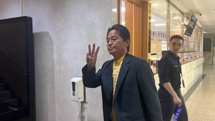 周克琦舉右手比出「3」的手勢。陳彩玲攝