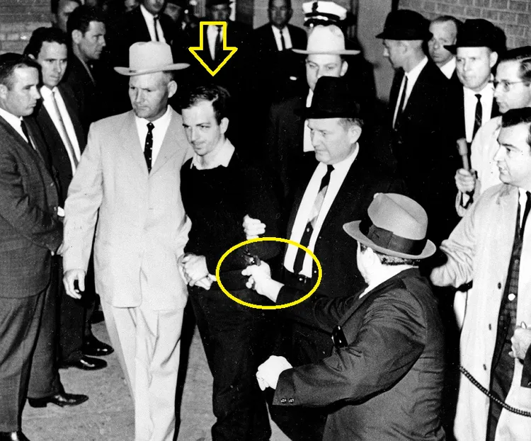 涉嫌暗殺甘迺迪的槍手奧斯華（箭頭）遭到一名夜總會老闆在電視直播時槍殺（黃圈）身亡。該名夜總會老闆後來在獄中「罹癌」病亡，他聲稱是被「下毒」致死。美聯社