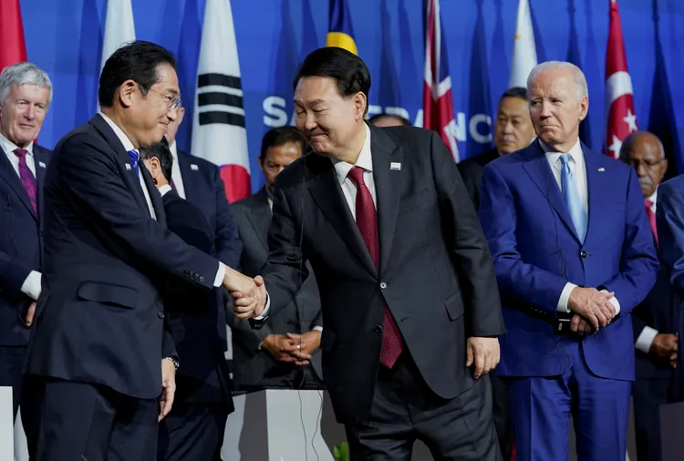 岸田文雄與尹錫悅16日在APEC峰會會場握手，右為美國總統拜登。路透社