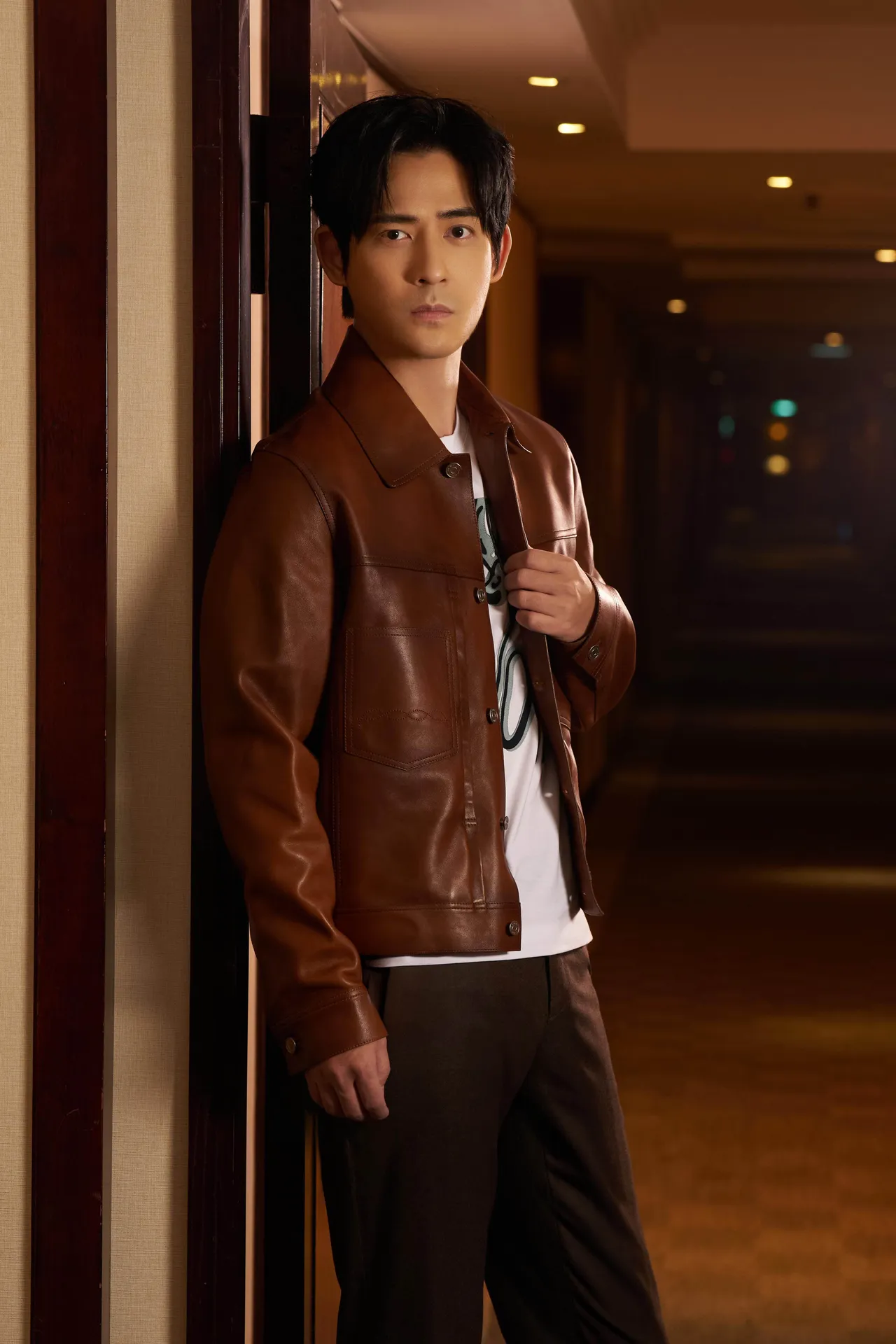 周渝民穿上Berluti 2023秋冬系列Patina古法染色皮革丹寧外套內搭白色Frame Scritto上衣，展現紳士魅力。品牌提供