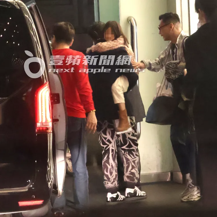 陳冠希（中）抱著女兒跟粉絲打招呼後，走進員工通道。特勤中心攝