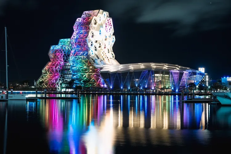 為迎接高雄同志大遊行，高雄流音中心前一晚特別以彩虹光芒點亮愛河灣。市府提供