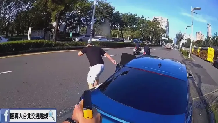 男駕駛疼痛不已以手遮擋。取自臉書「翻轉大台北交通違規」