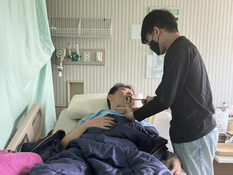 中原醫工王明誠老師因病無法自理，學生細心餵食。中原大學提供