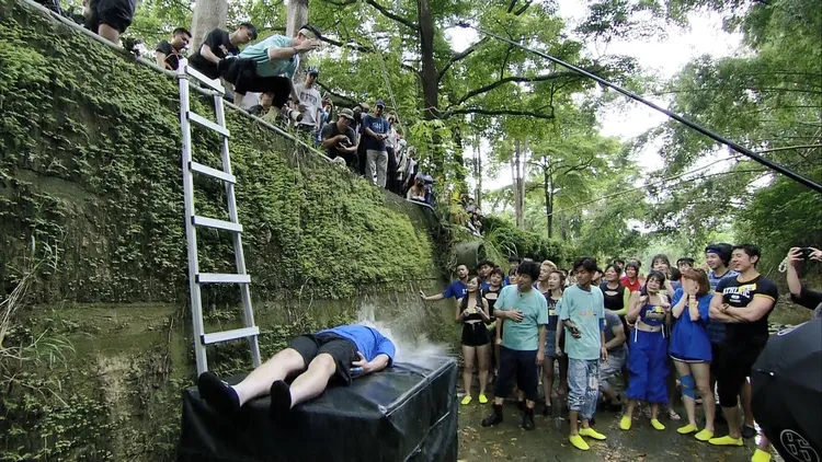 無尊（躺下者）猜輸拳了，代打上陣，罰被水球砸臉。民視提供