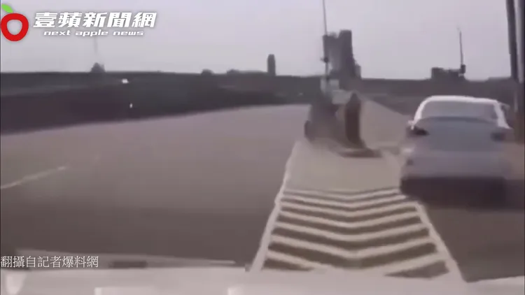 不斷擋路的白車駕駛，遭後車欺敵戲耍騙往右側上引道，後車駕駛迅速切回原車道離開，影片紅到國外。翻攝自記者爆料網