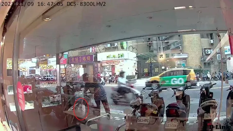 中年男騎士提起一大袋垃圾(紅圈處)，偷偷擺到旁邊的機車踏板上。翻攝自臉書「信義區三兩事」