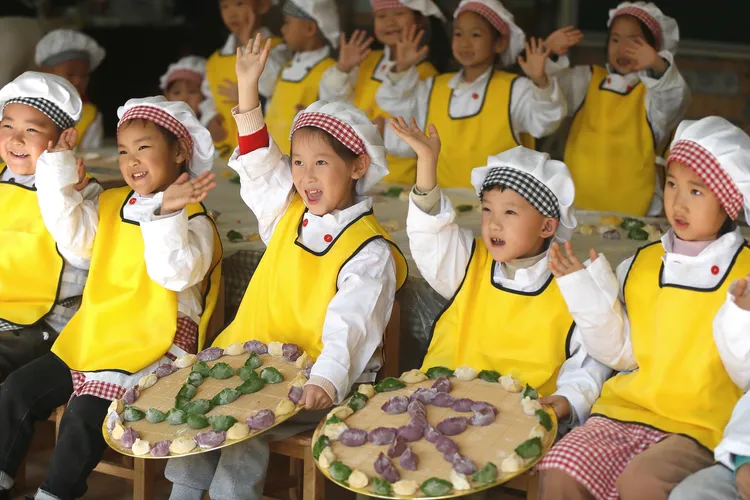 山東青島一間幼稚園的學童展示自己包的餃子。新華社