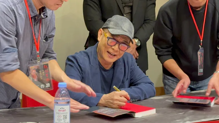李連杰替粉絲簽書。攝影中心攝