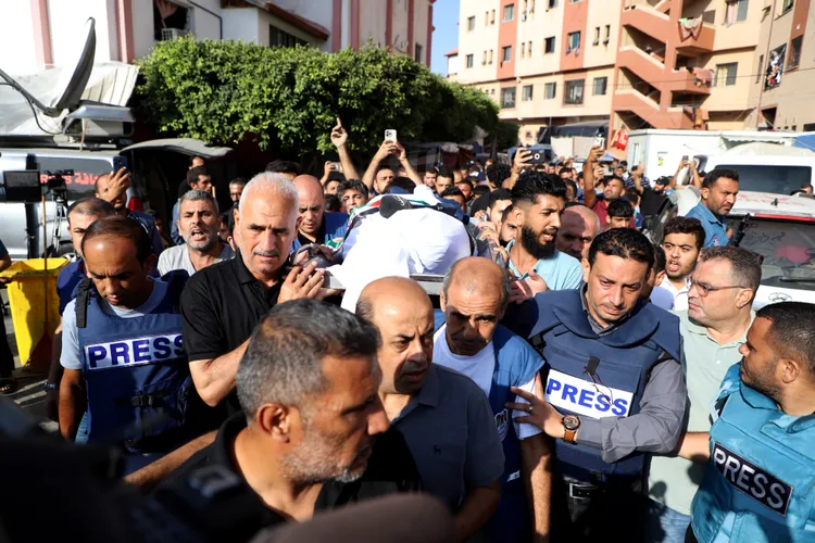 媒體人抬著哈塔布遺體。路透社