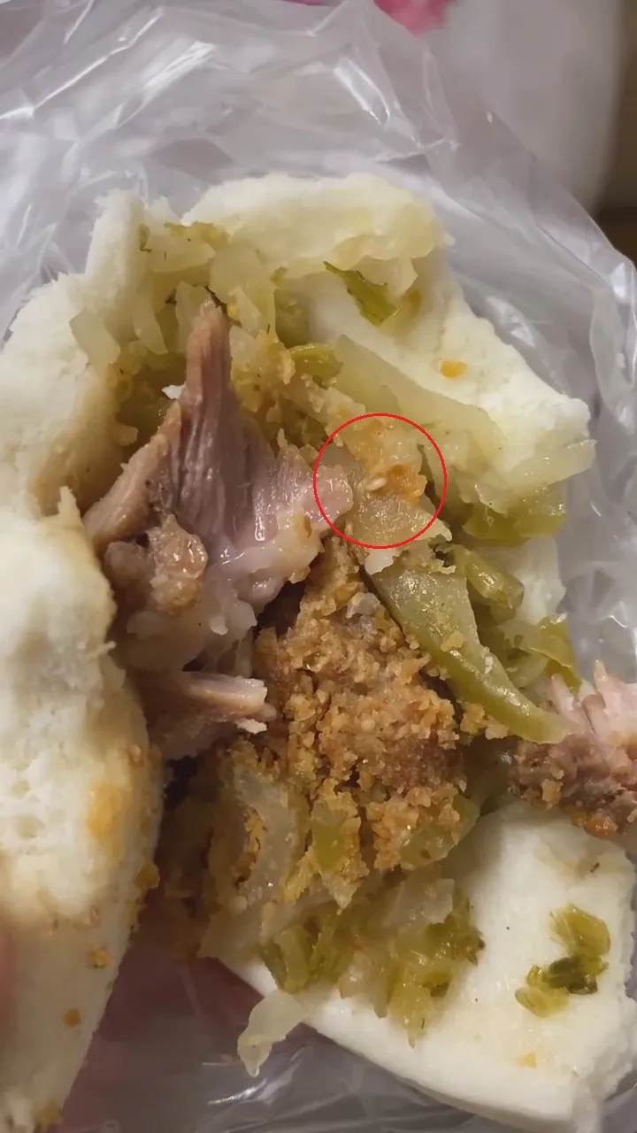 刈包內酸菜上有蛆(紅圈處)爬行。翻攝自臉書「爆廢公社二館」