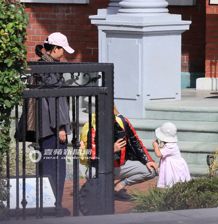 到了一旁的展館花園，黃子佼（中）拿起手機記錄小玉米可愛的模樣。特勤中心攝