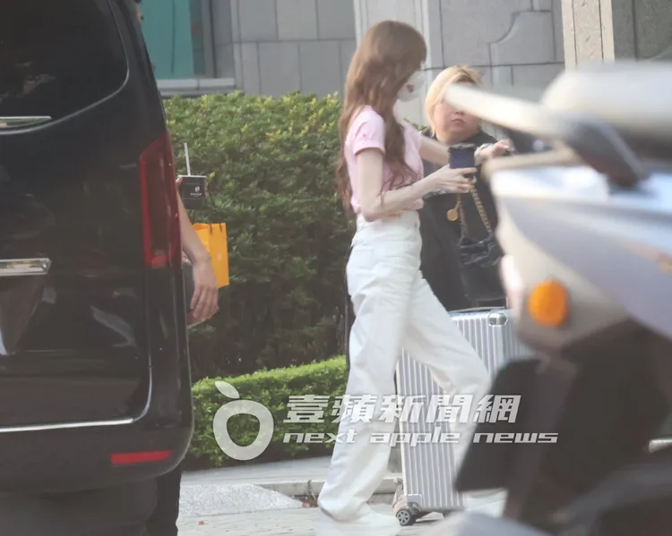 王心凌（左）走進索尼唱片公司繼續上班，助理在旁幫忙提行李箱。特勤中心攝