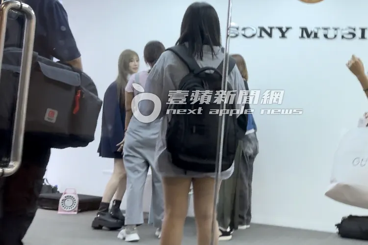 王心凌（左）換上迷你短裙、搭配黑馬靴，披著西裝外套和工作人員討論內容。特勤中心攝