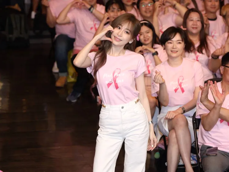 王心凌（前）身穿粉紅力量公益活動T恤，比出臉頰愛心和來賓們大合照。特勤中心攝
