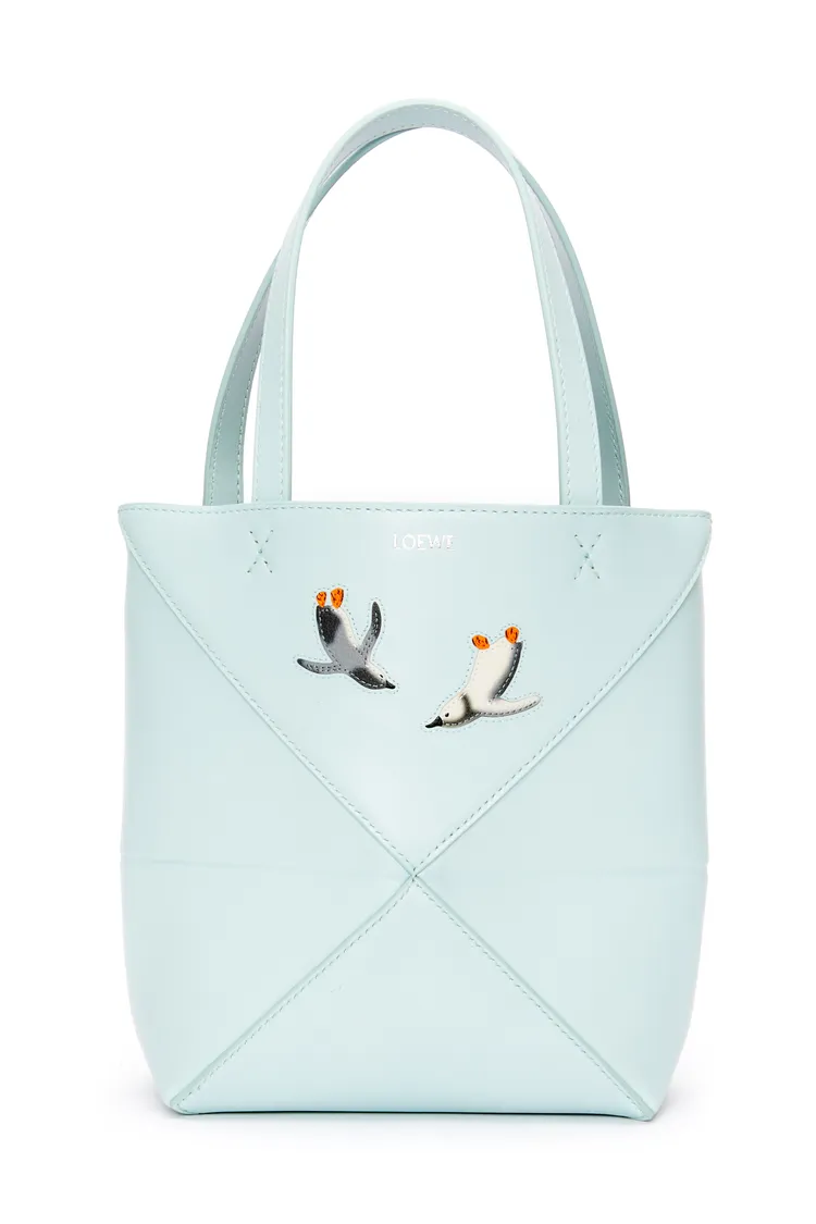 Puzzle Fold冰川藍企鵝刺繡小牛皮托特包，價格店洽。品牌提供