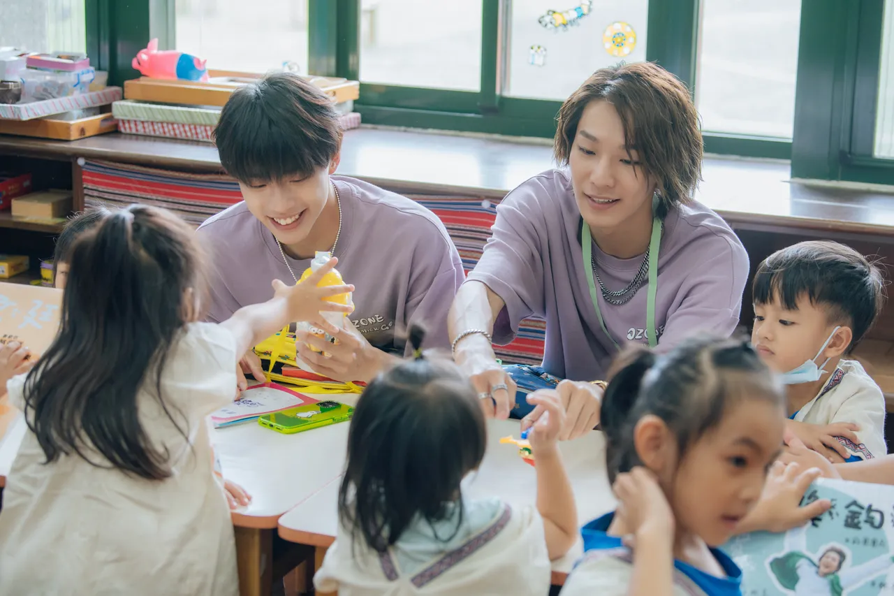 男團Ozone的文廷(左)、煥鈞與幼兒園學生玩在一塊。寬想國際娛樂提供