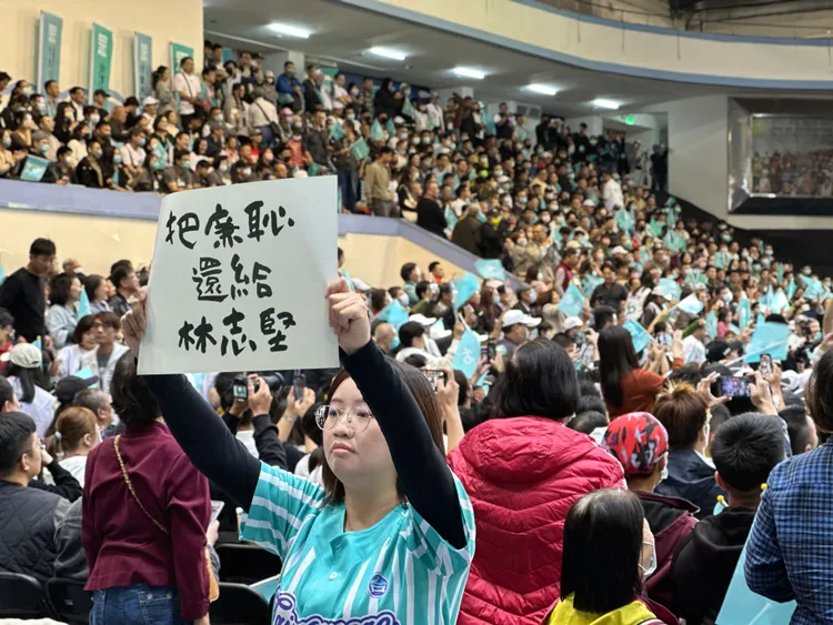 民眾黨誓師大會上舉牌抨擊民進黨政府標語的志工。潘袁詩羽攝