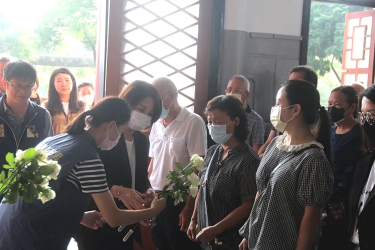 周春米獻上白玫瑰向烈士家屬致意。縣府提供