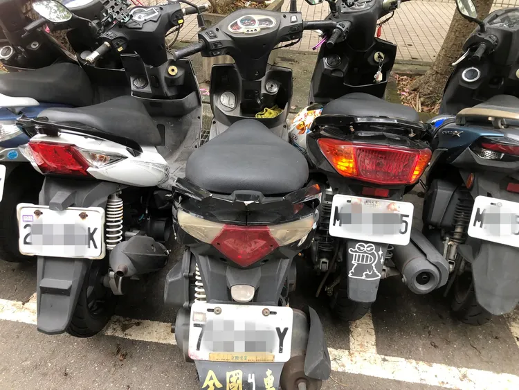 女大生機車停在車格內，卻被兩輛機車硬擠動彈不得，其中一輛機車擠不進去只塞進一半，讓她氣炸了。翻攝臉書「爆料公社公開版」