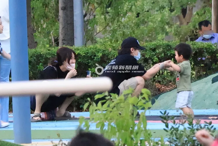 鄧福如（左）亞洲蹲姿勢，開心看著兒子與HowHow玩耍。特勤中心攝