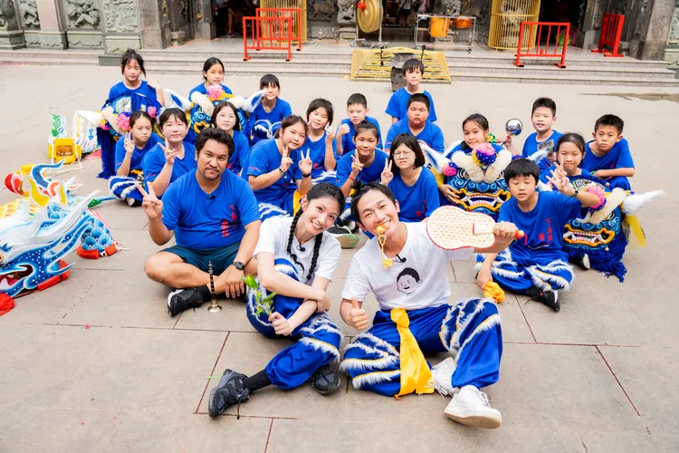 李千娜（前排左一）、蔡昌憲與下崙國小的團員學習「龍鳳獅」。民視提供