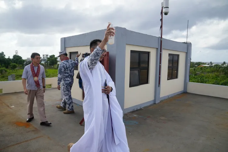 一名教士在中業島的海岸防衛站灑聖水祈福。美聯社