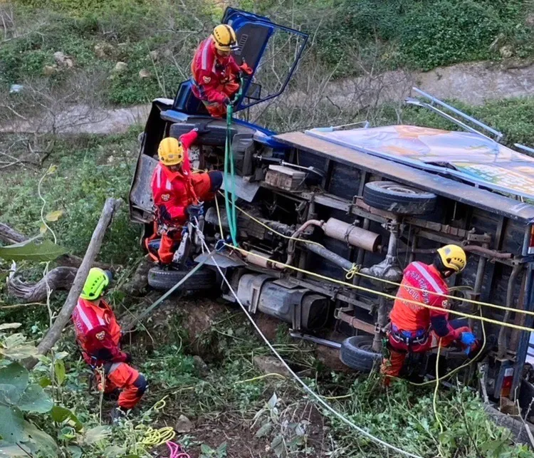 宣傳車滑落溪谷後翻覆，消防人員搶救受困駕駛。民眾提供